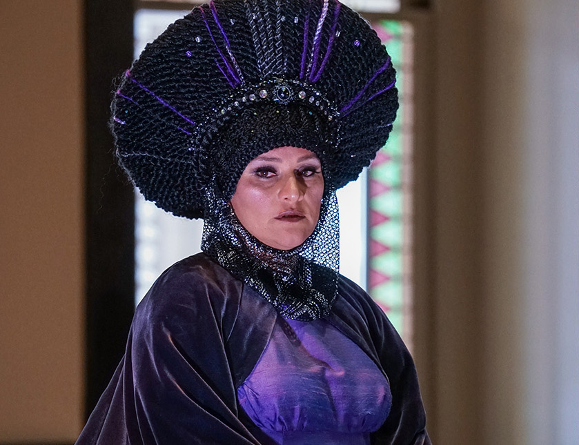 Woman dressed in a regal costume with a large hat