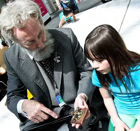 Volunteer showing child a historical object