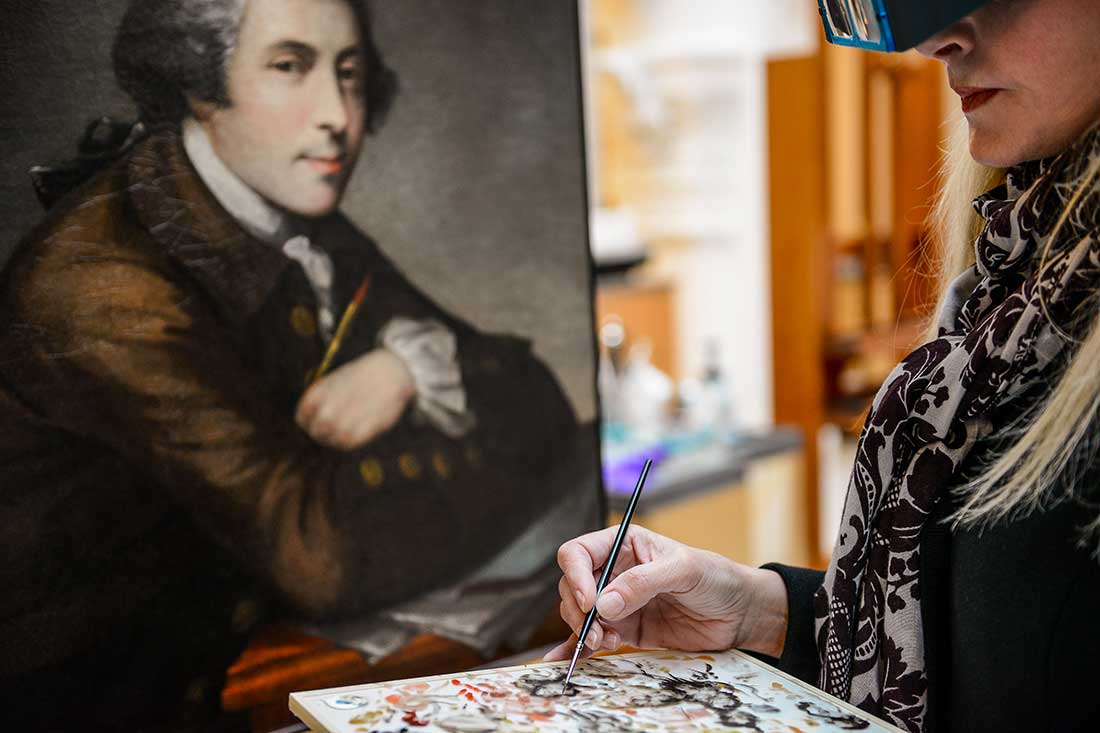 Painting conservator working on in-painting