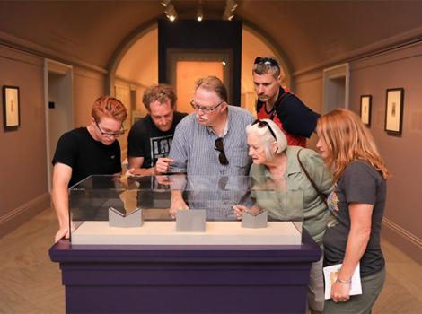 group of adults clustered around a vitrene