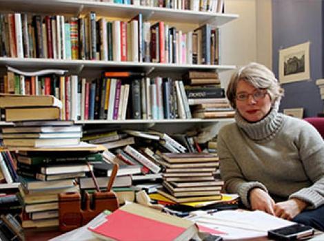 Woman seated in an office filled with books