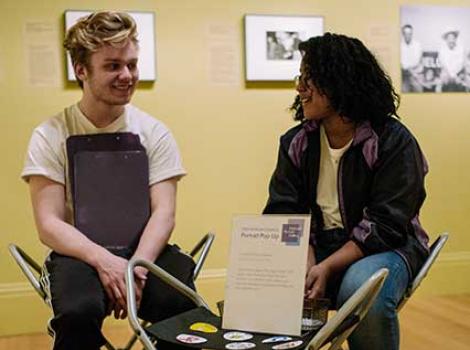 Two teens sitting in folding chairs talking