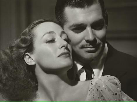 Still image of a classic black and white movie with a well-dressed man holding a woman