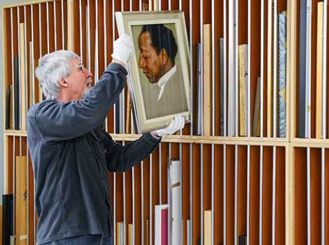 NPG staff member handling a portrait.